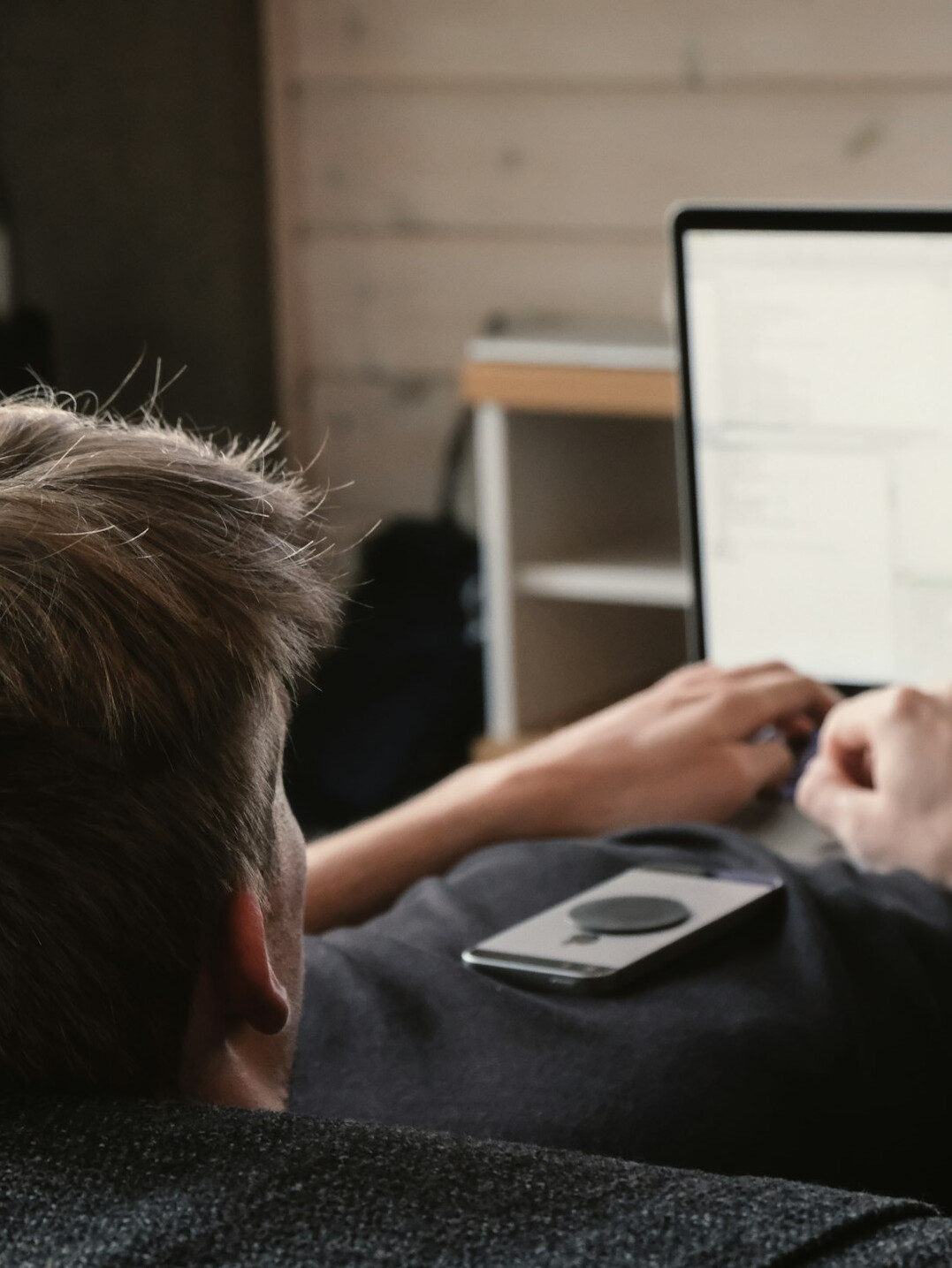 young man coding on laptop