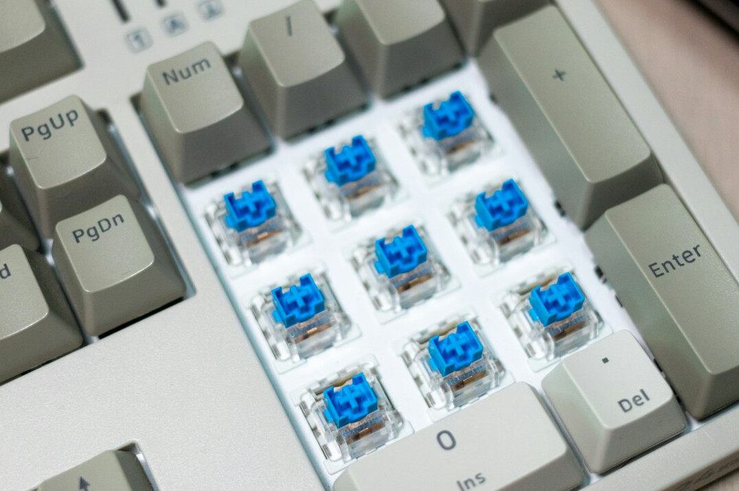 Close-up of hands typing code on a mechanical keyboard