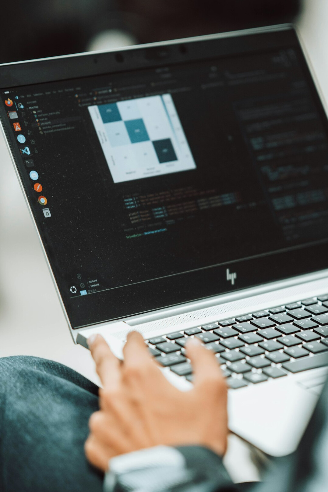 young person coding on laptop